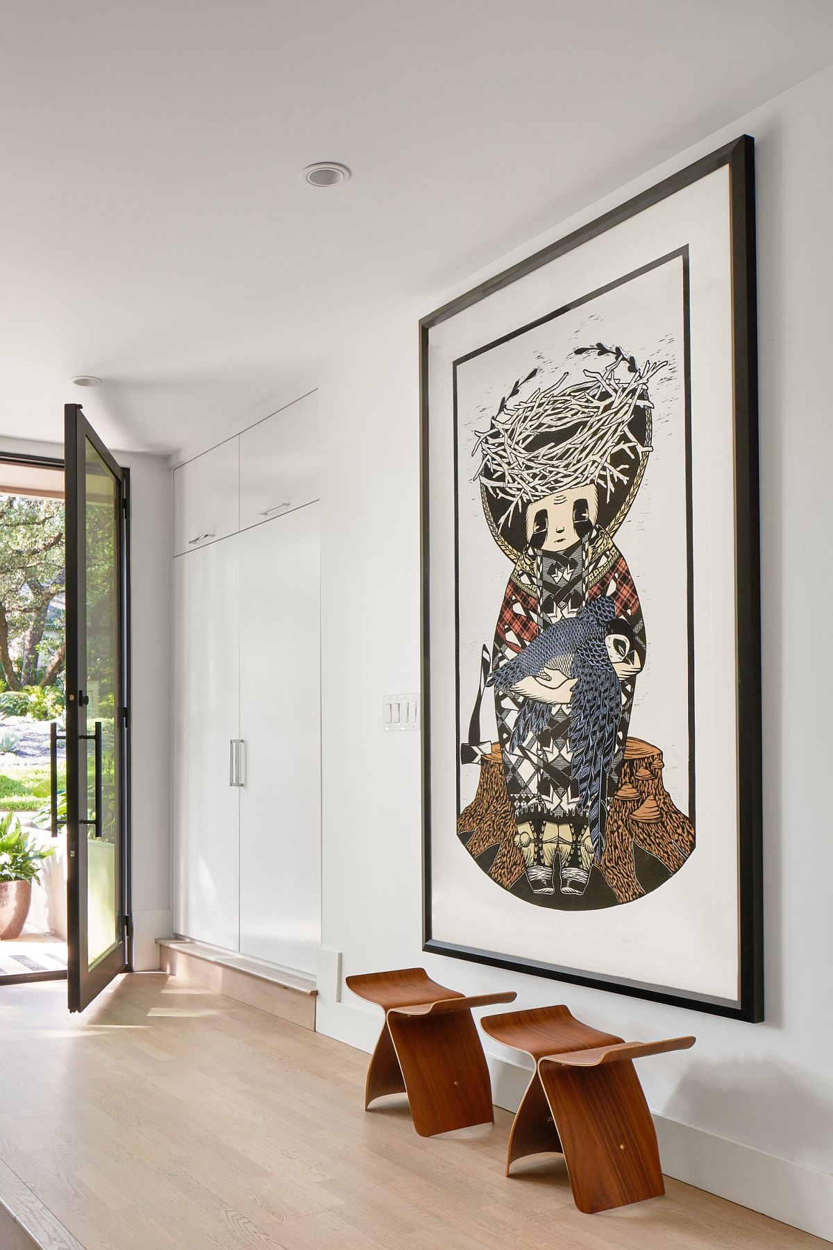 Awesome wall art steals the show in this spacious white modern entry space