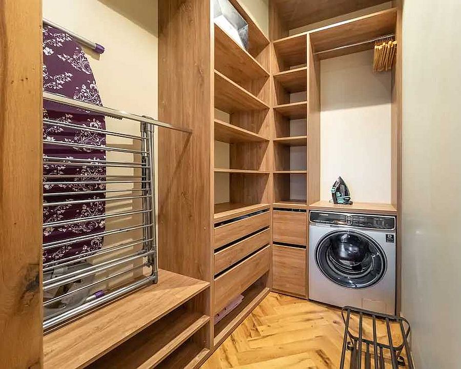 Beautiful laundry room in wood and white inside the small Tbilisi apartment