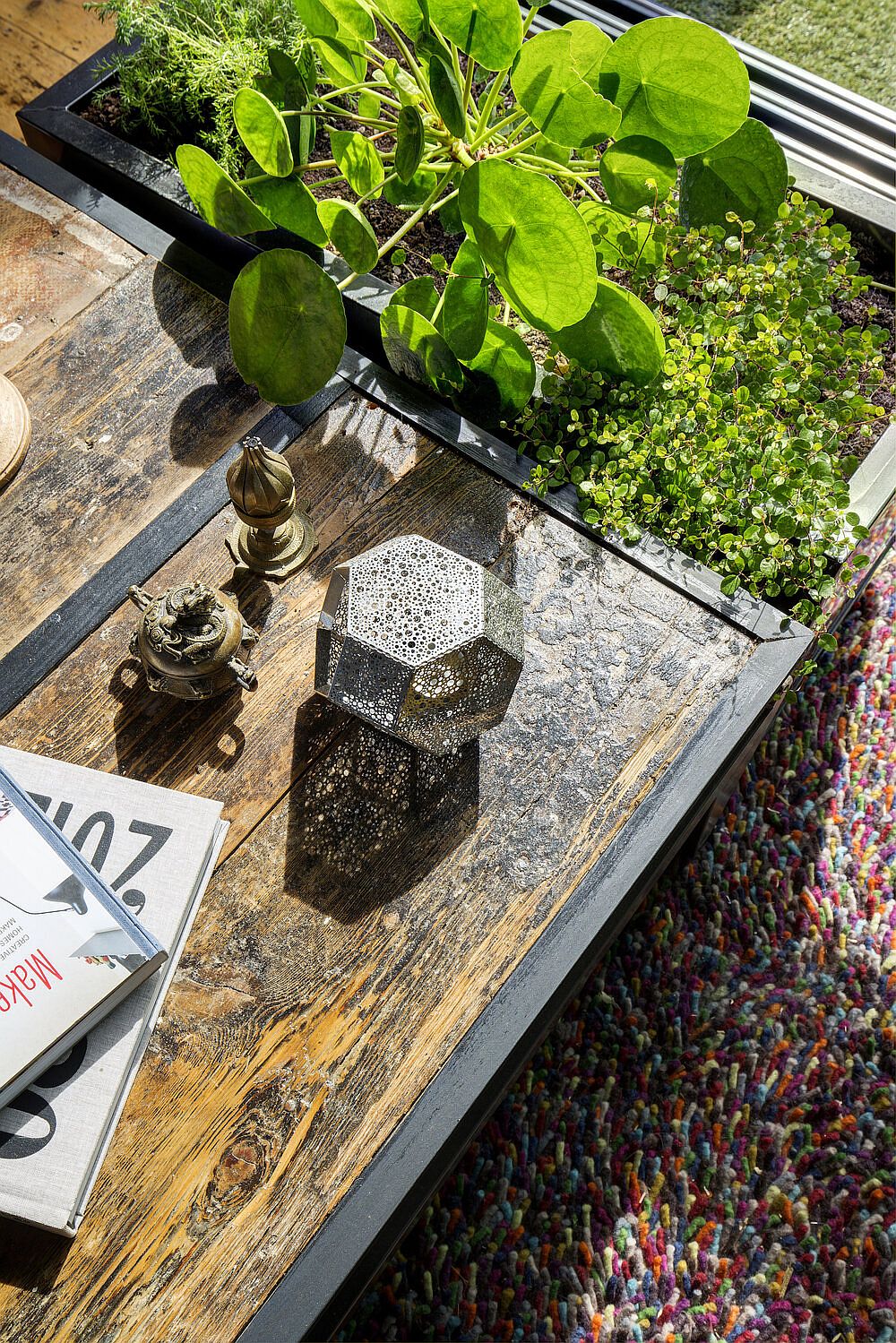 Closer look at the reclaimed wood and metal coffee table and green planter next to it