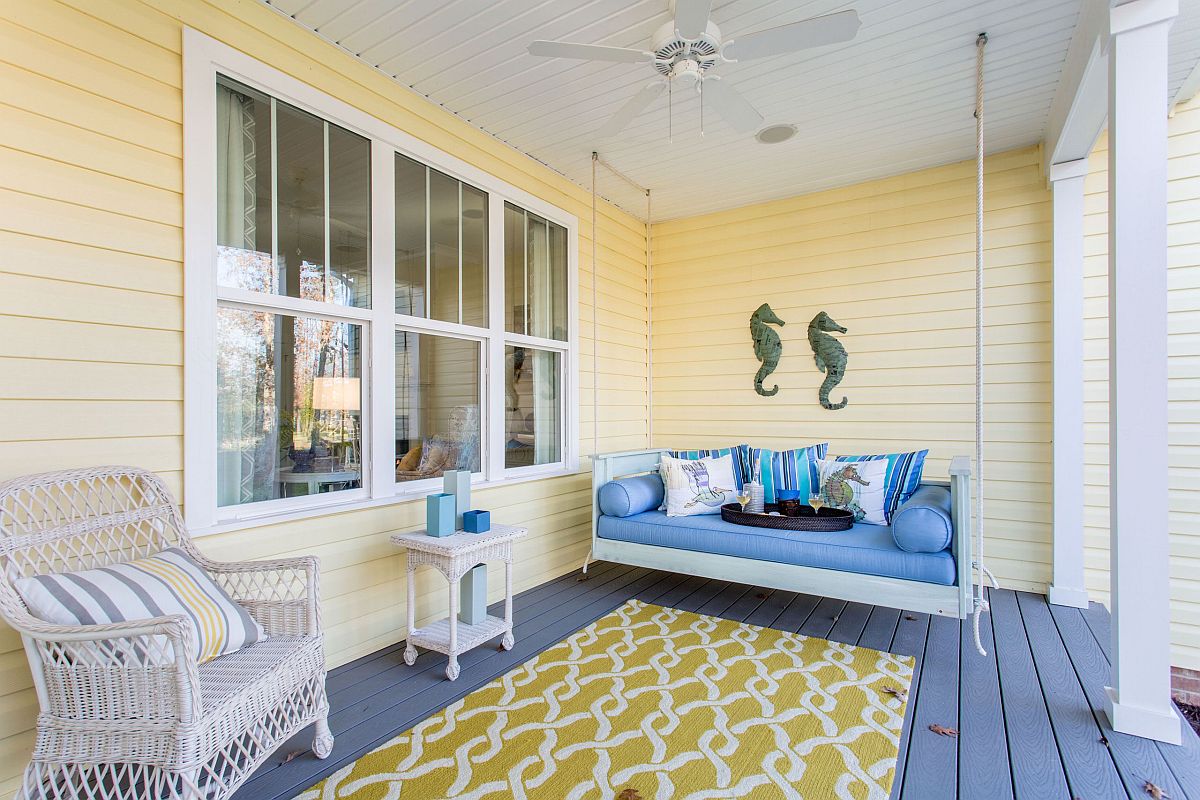 Combining yellow with blue in the spacious porch that has a swing