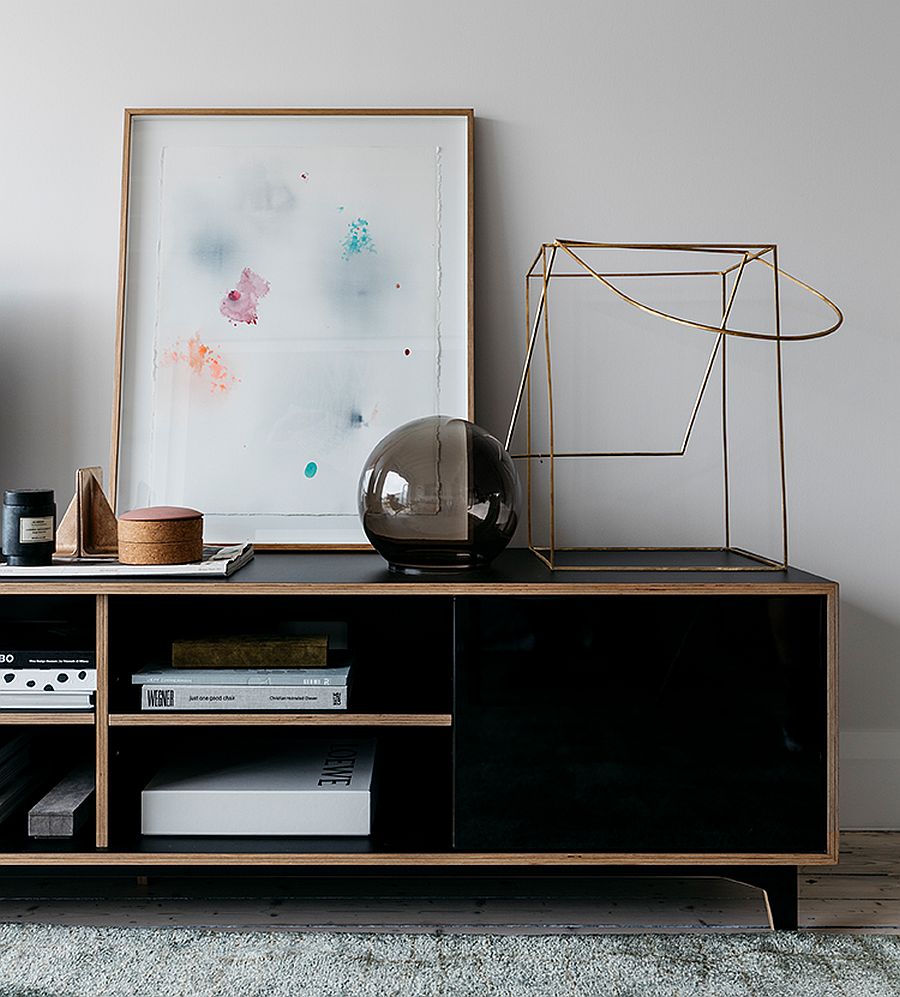 Decorating the beautiful black credenza in wood in the living room with sculptural and artistic pieces