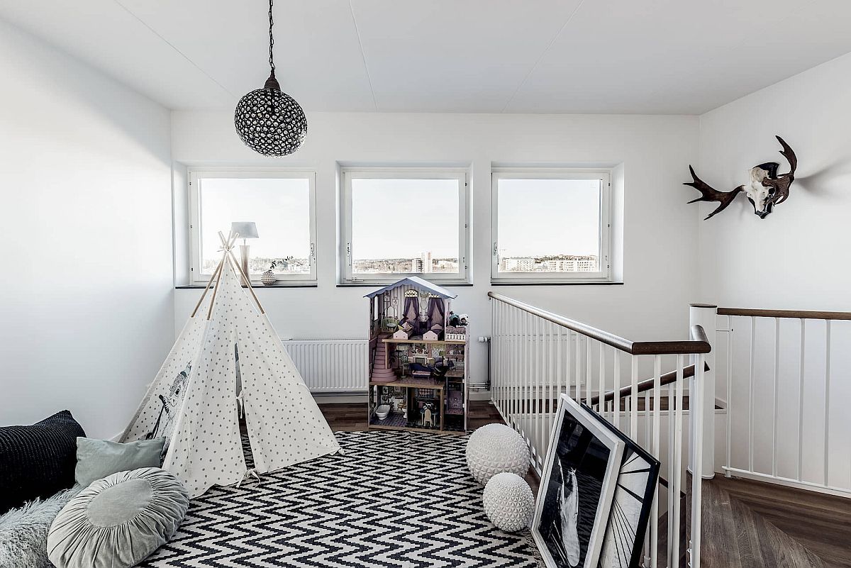 Fabulous gender-neutral kids' playroom with Scandinavian style in black and white sits in the staircase landing area