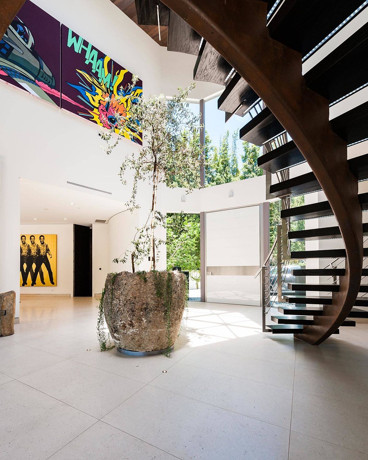 Fabulous indoor plant along with spiral staircase for the posh modern entry