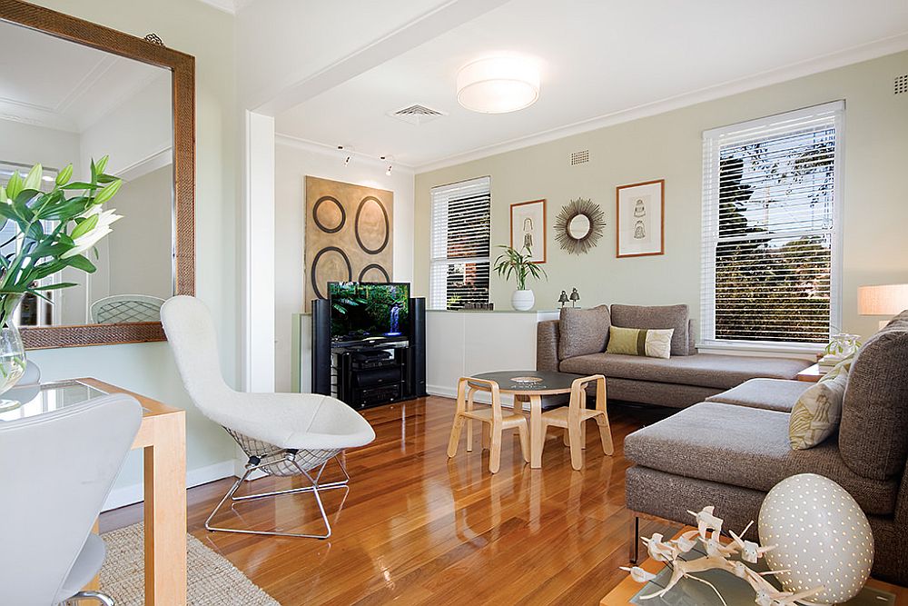 Family room of the home in white with wooden floor and sofas in dark gray