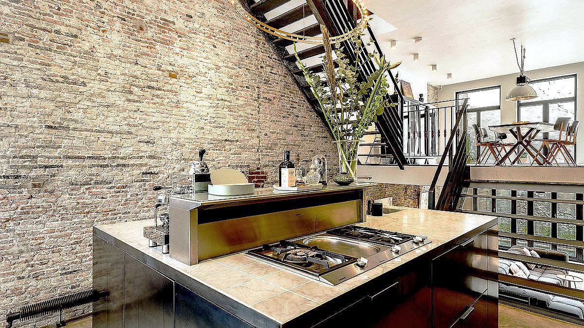 Metal staircase connects the split-level living area, kitchen and dining space