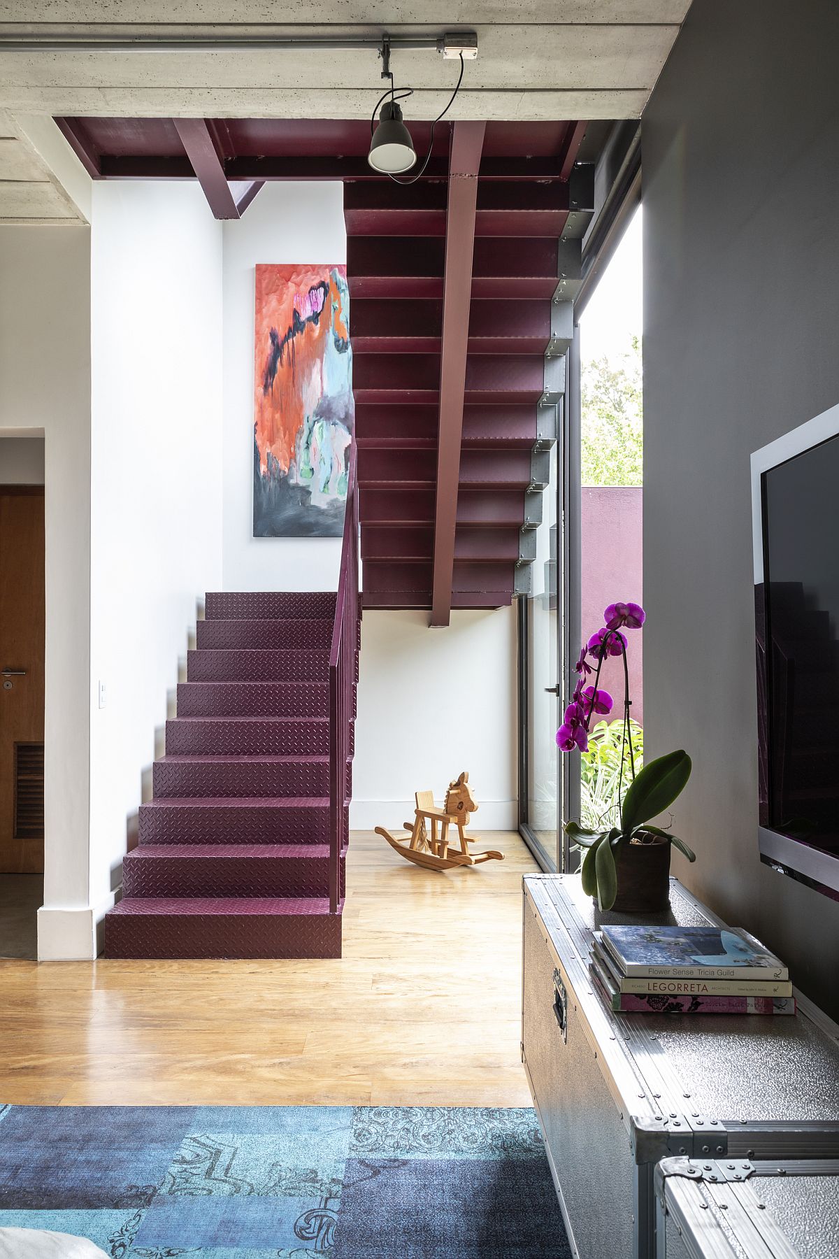 Metallic staircase in bright red brings color and contrast to the modern interior