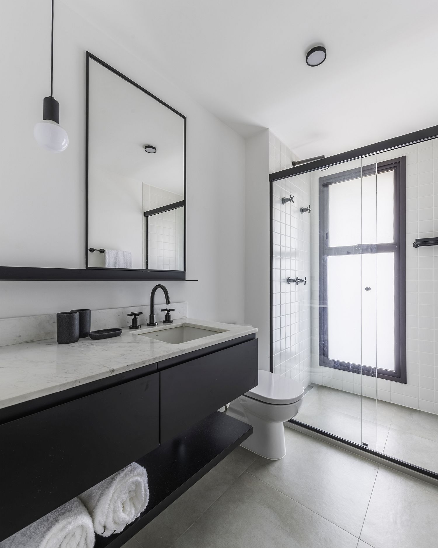 Modern and minimal bathroom in black and white with concrete finishes