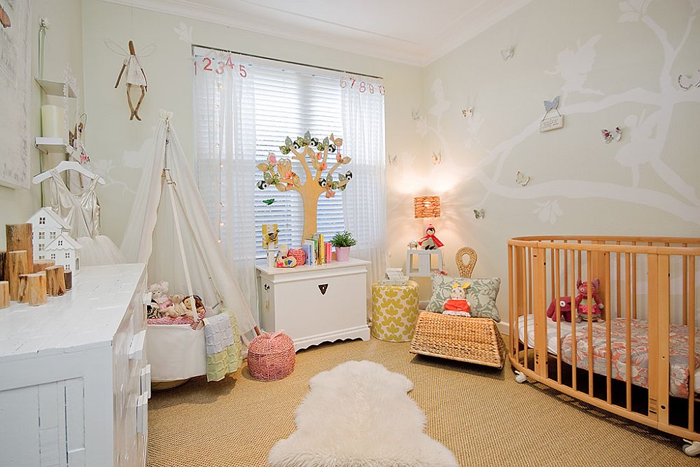 Nursery with custom wall decal, white walls and a beautiful playarea in the corner