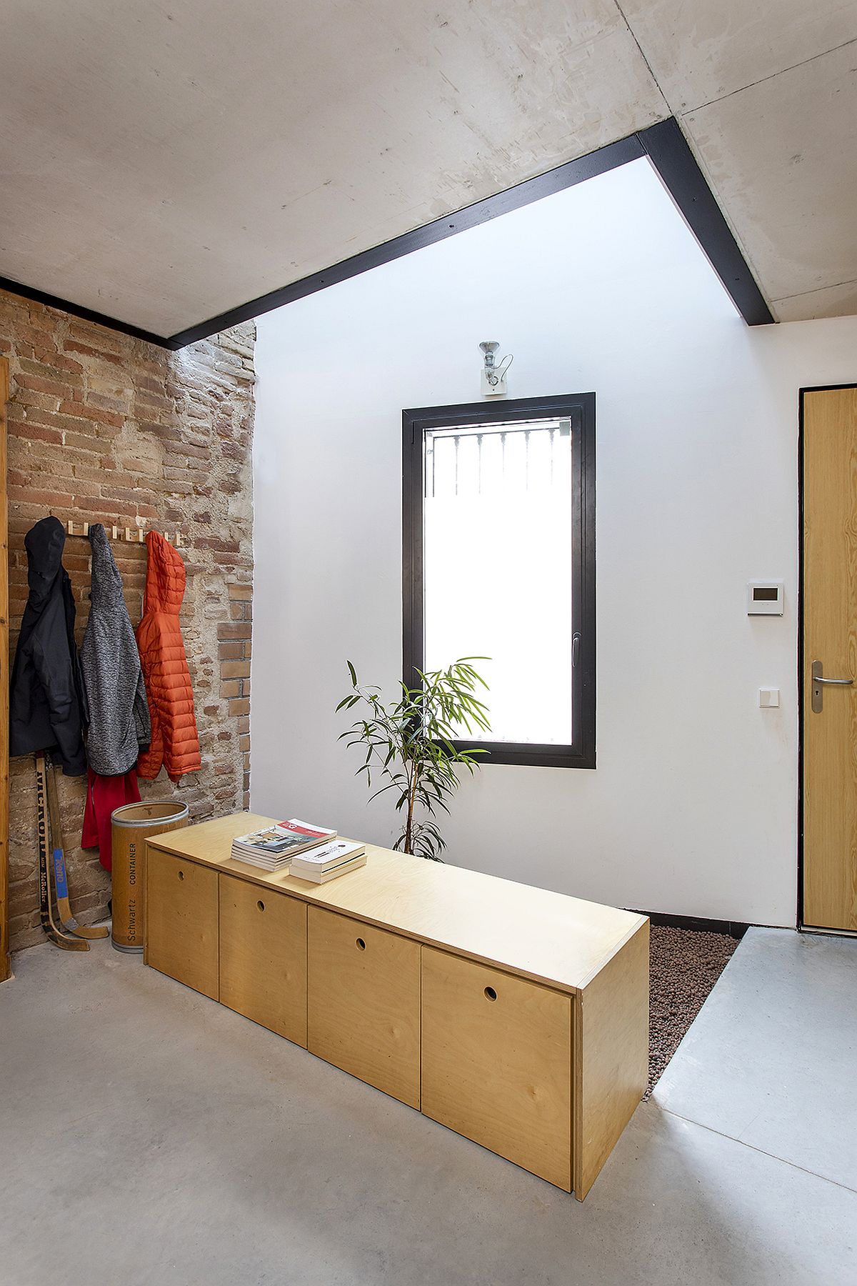 Skylight brings natural light into the entry in white, brick and wood