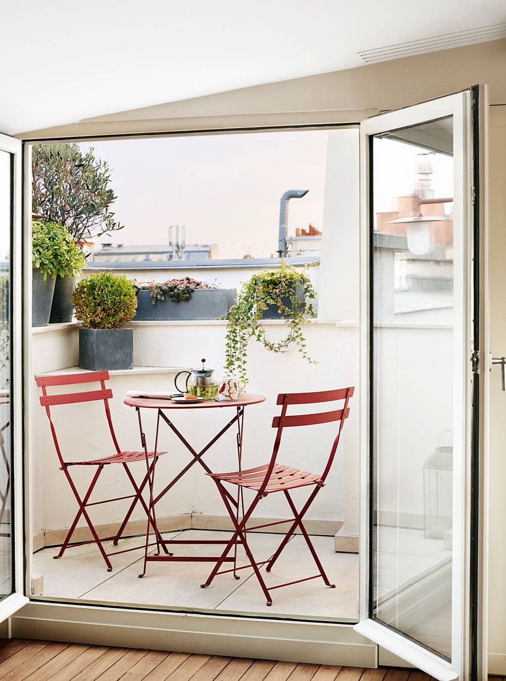 Slim table and chairs in red for the tiny Balcony of Paris home