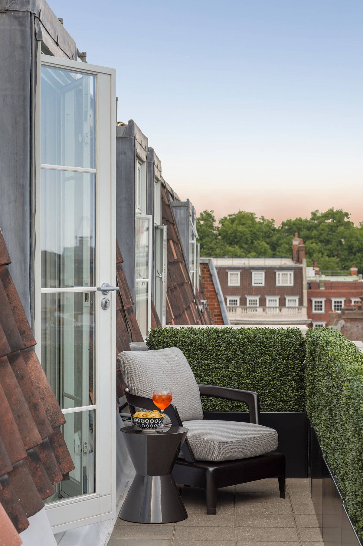 Small side table combined with a comfy chair and wall of greenery for the private balcony