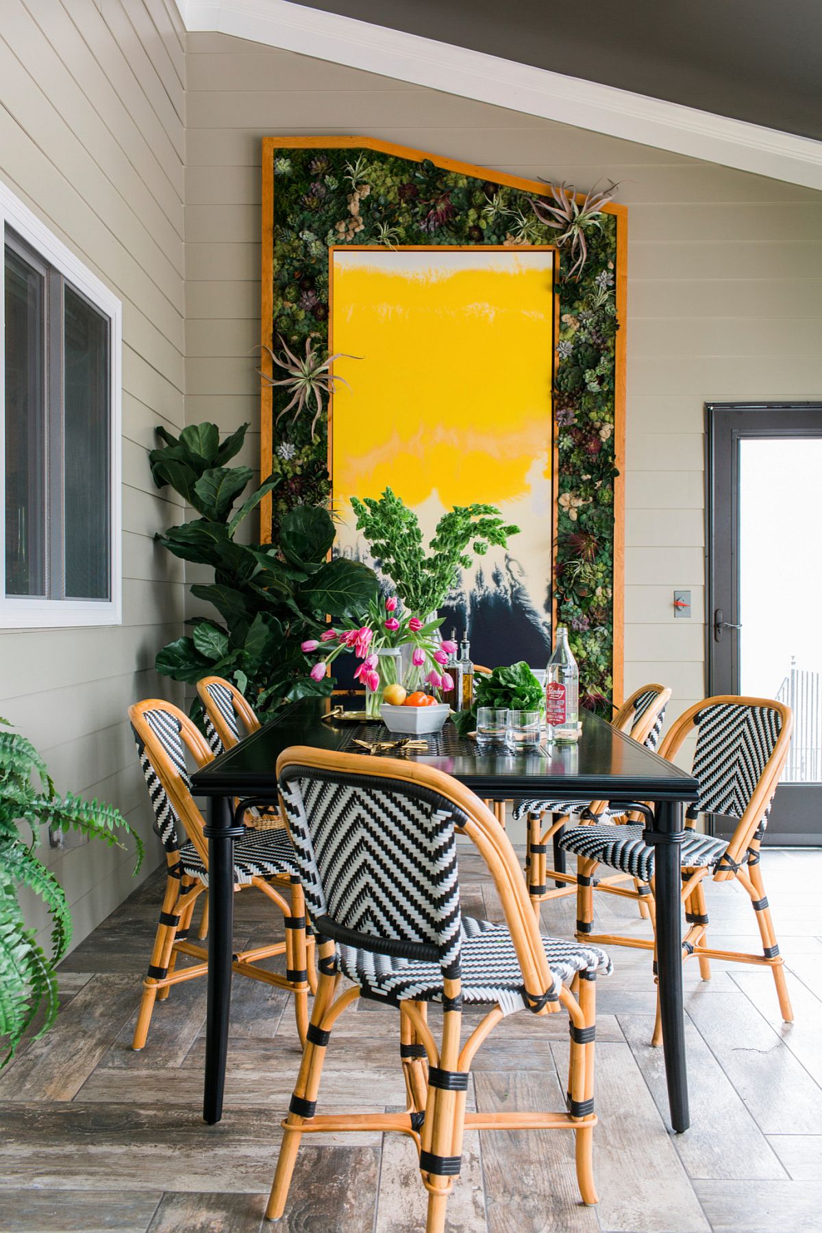 Stylish screened porch with gorgeous pops of yellow and green and chairs with chevron pattern