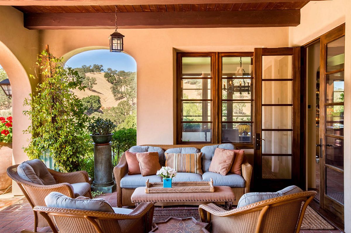 Textured walls in pastel orange and dashing wooden beams give this Mediterranean porch a captivating appeal