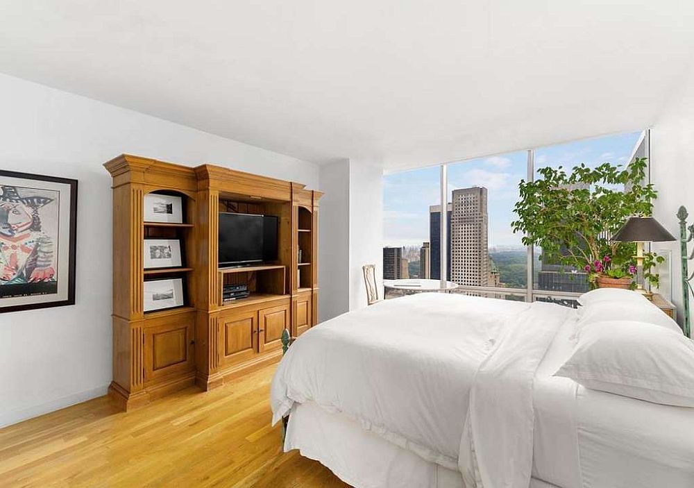 Awesome Central Park views await inside this small bedroom of the apartment with plenty of floor-to-ceiling glass walls