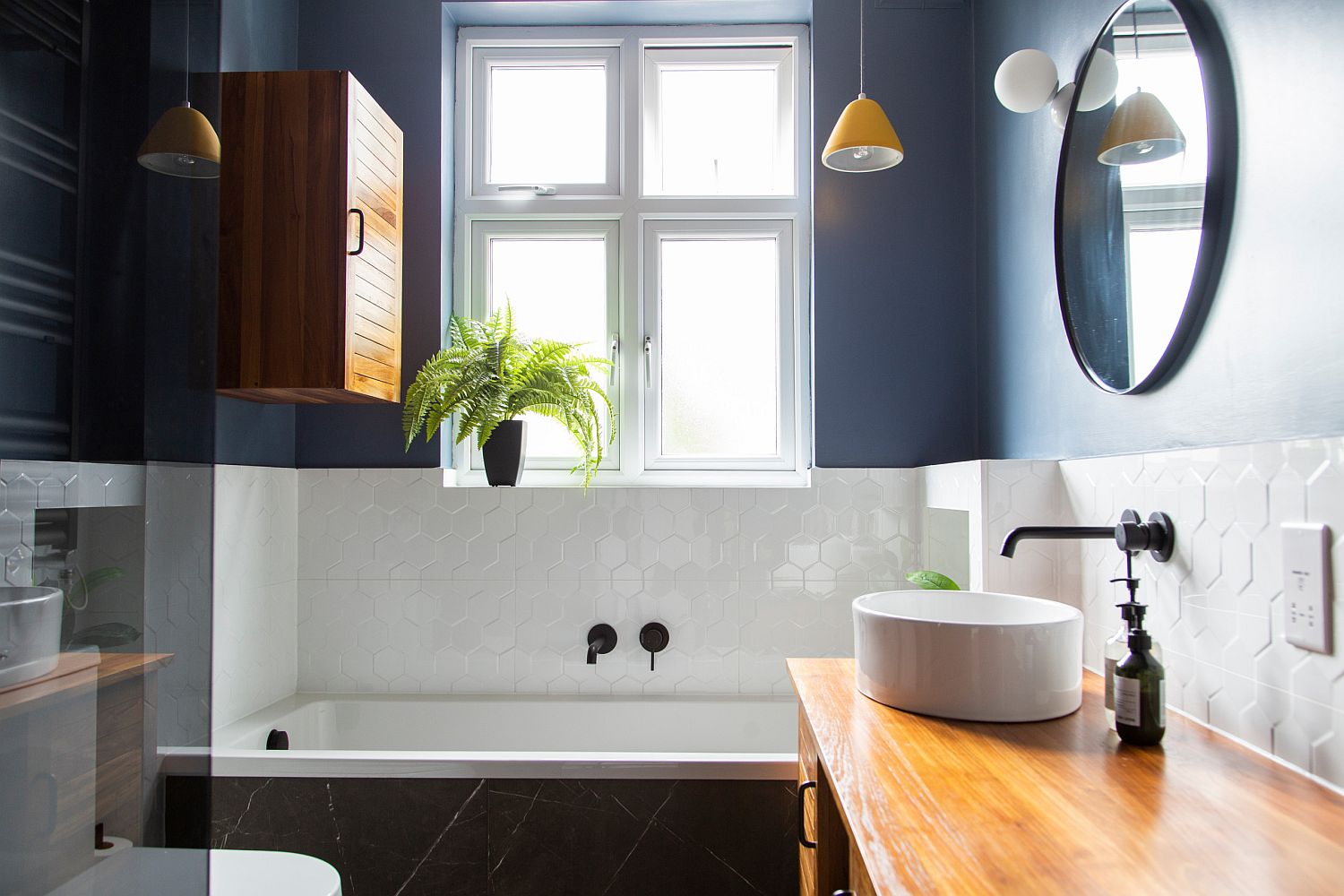 Blue-walls-white-tile-and-warm-wooden-vanity-create-a-delightful-balance-of-elements-inside-this-London-bathroom-52285