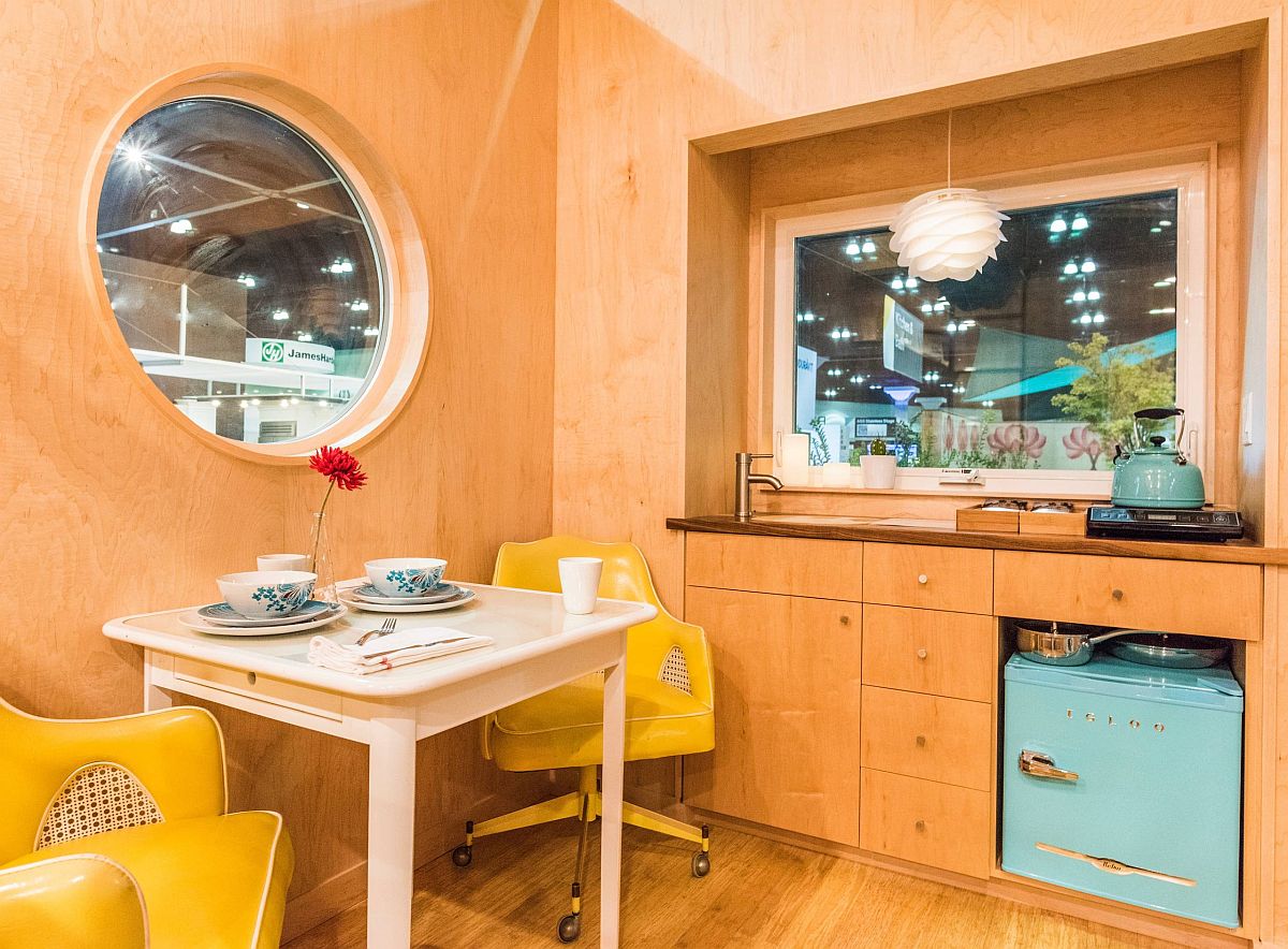 Breakfast area and home workspace are both the same in this tiny mobile home with walls in wood