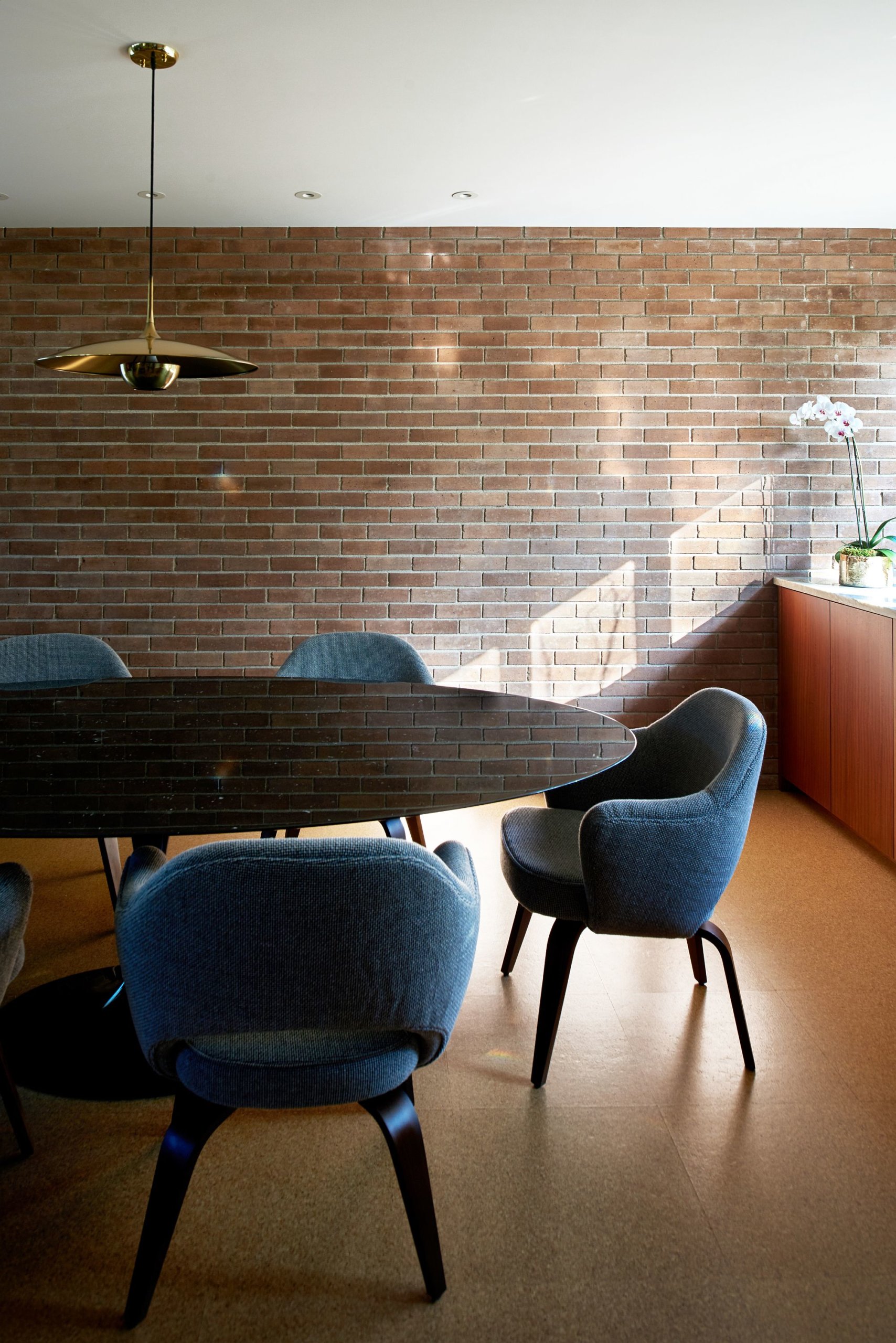 Brick walls give a modern-classic appeal to the light-filled dining room