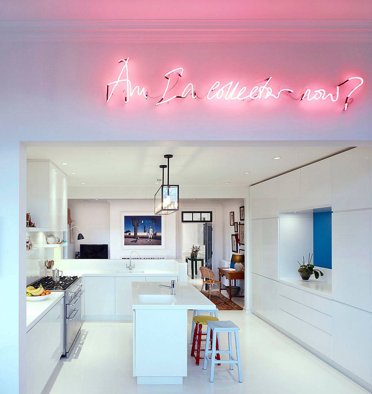 Bright neon sign illuminates the kitchen and living area inside this white Chelsea apartment