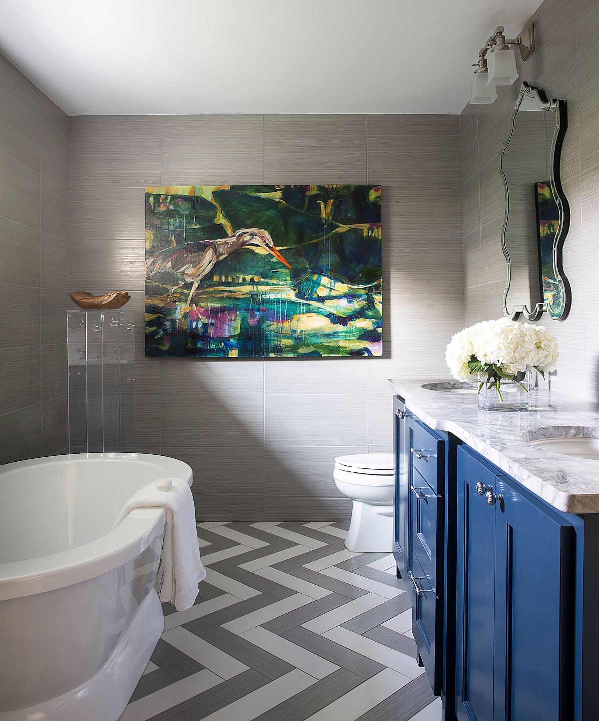 Chevron pattern floor in white and gray along wth blue vanity in the contemporary bathroom