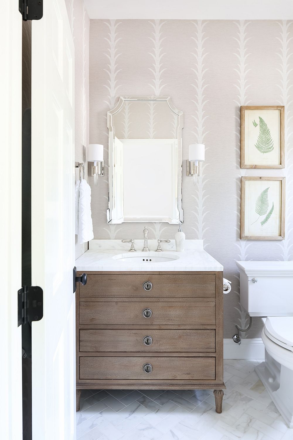 Couple of framed botanical prints bring color to this modern bathroom in neutral hues