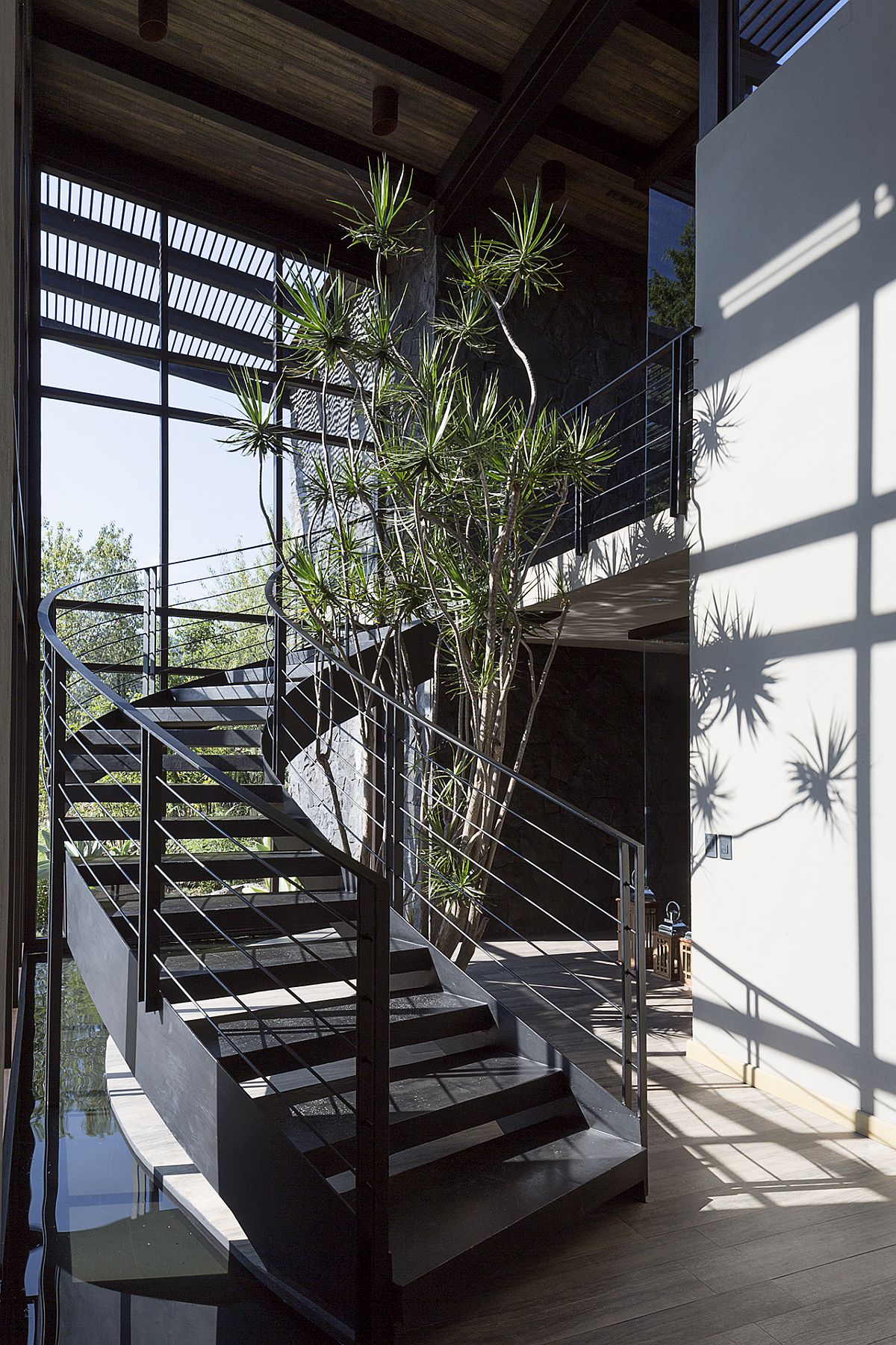 Curvy staircase along with the water feature creates a stunning entry space