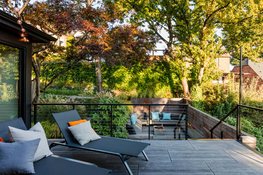 Deck of the house in wood with staircase that leads to the sunken patio below