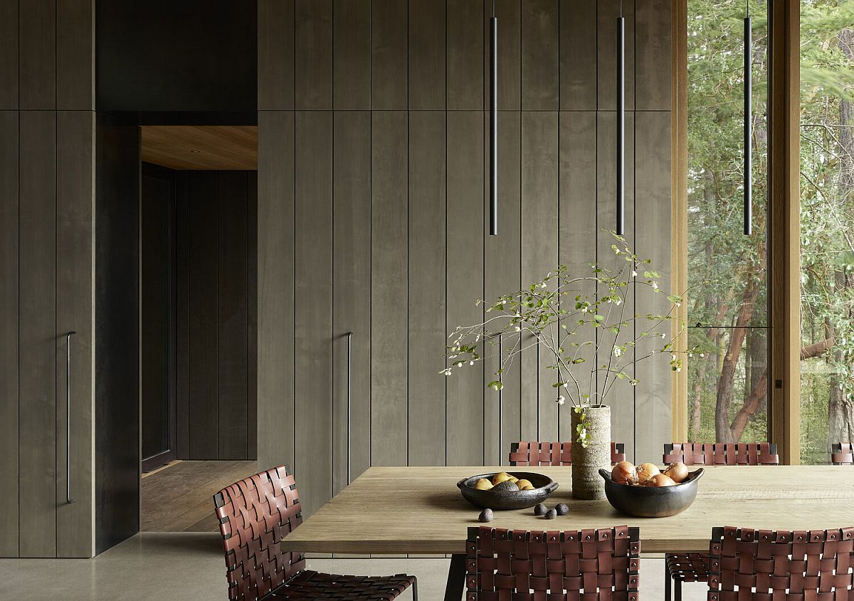 Dining area of the house with rustic style and glass walls all around