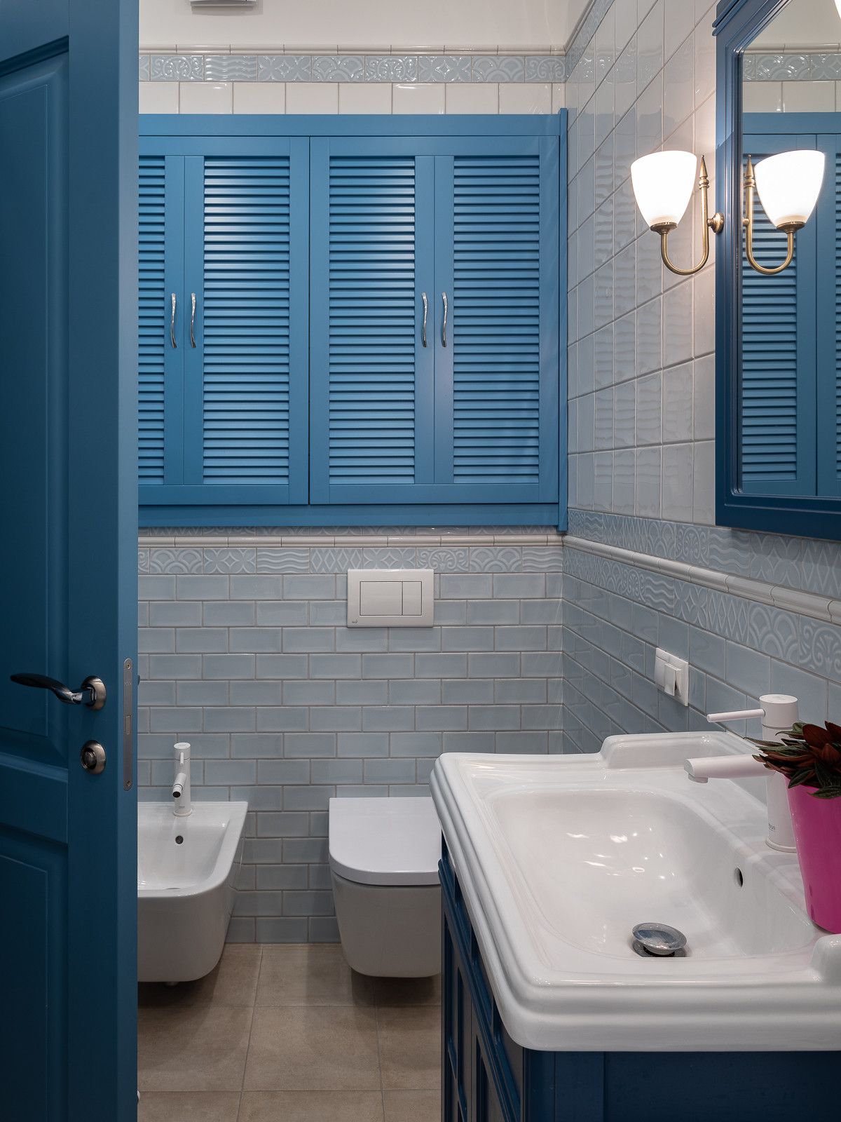 Door, window shutters and vanity bring blue to this small traditional bathroom