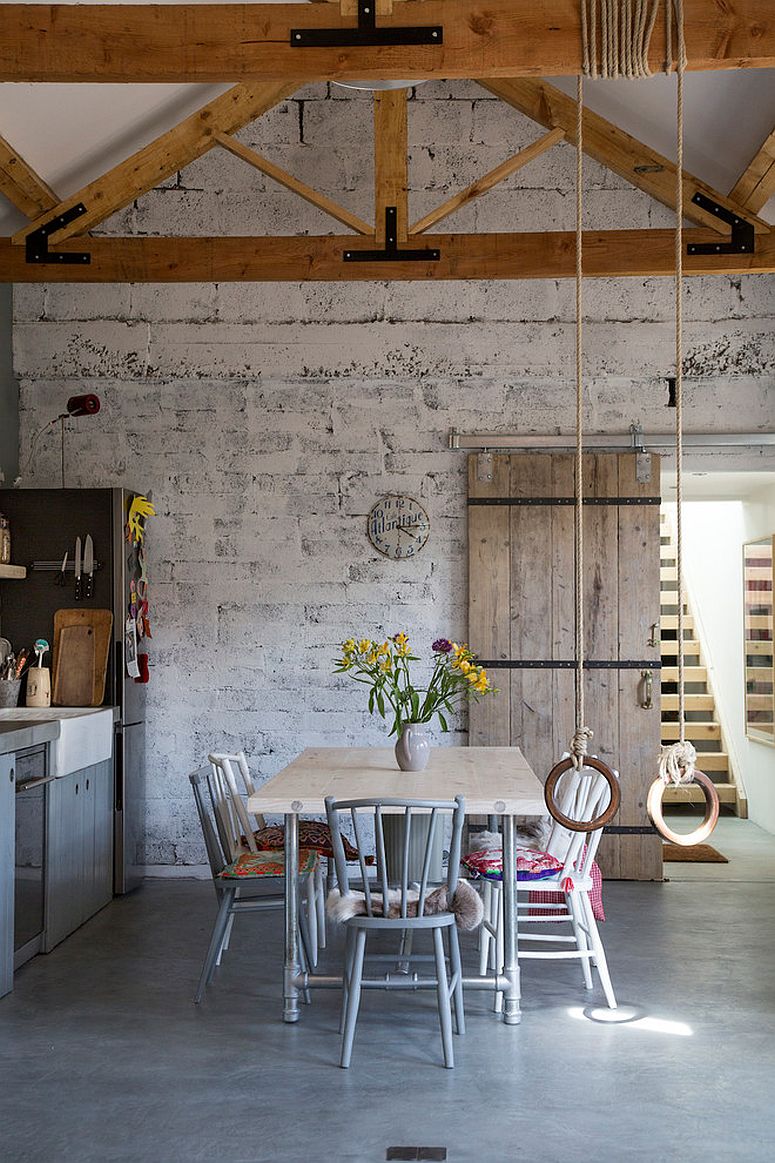 Double-height dining room of the classic home with whitewashed brick wall backdrop