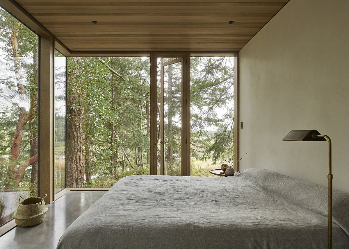 Folding glass doors connect the bedroom with the greenery outside