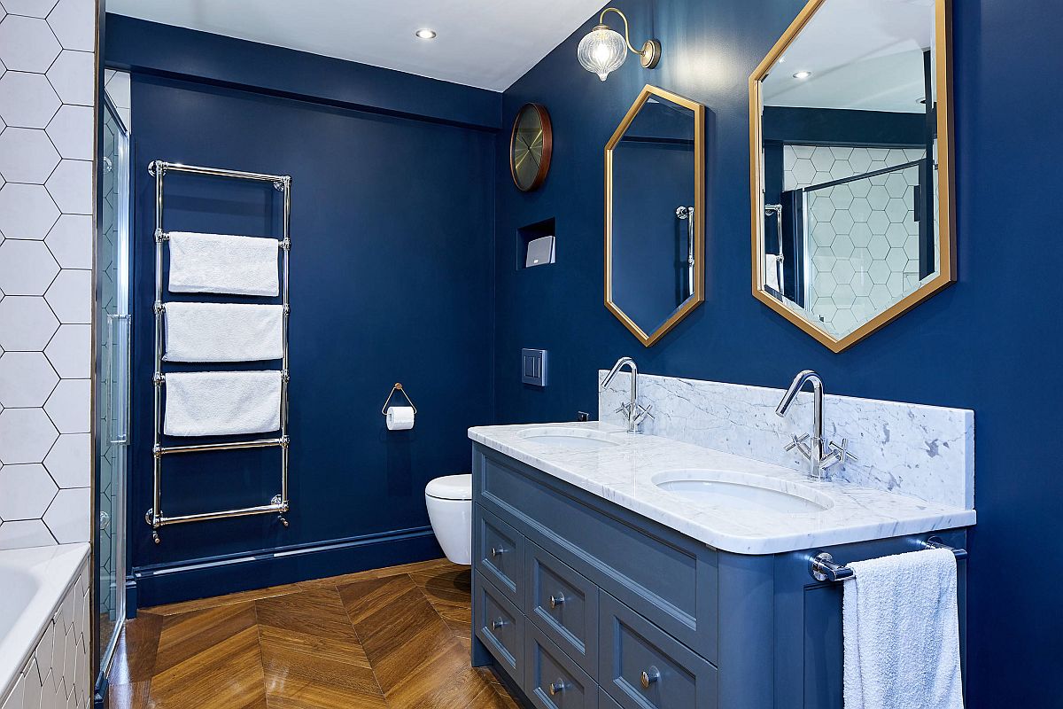 Le cornici degli specchi esagonali aggiungono glitter metallici a questo splendido bagno blu e bianco