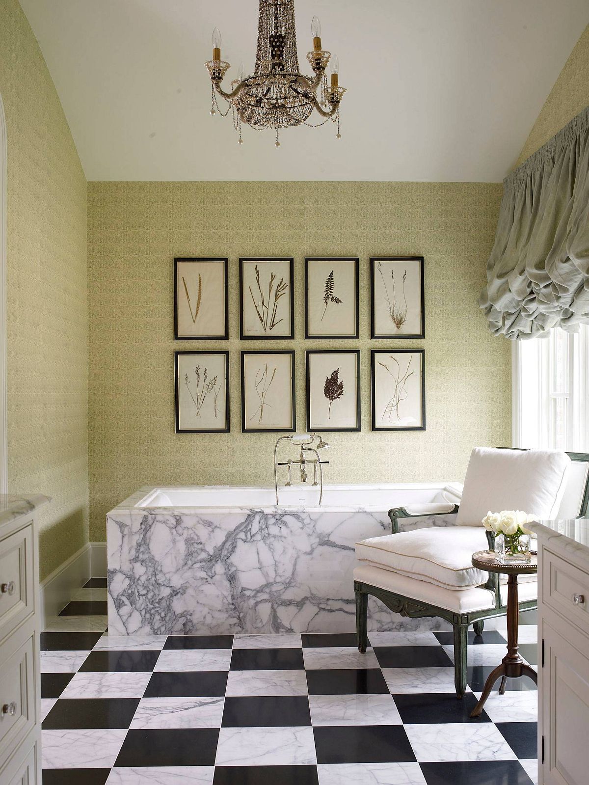 Green and white bathroom with black and white tiles and framed botanical prints on the accent wall