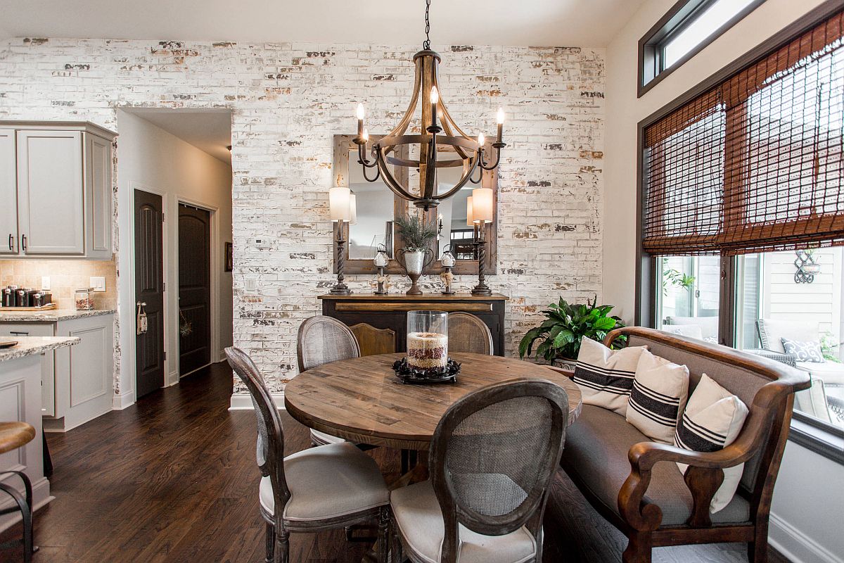 Imperfections of the whitewashed brick wall accentuate the beauty of this dining room