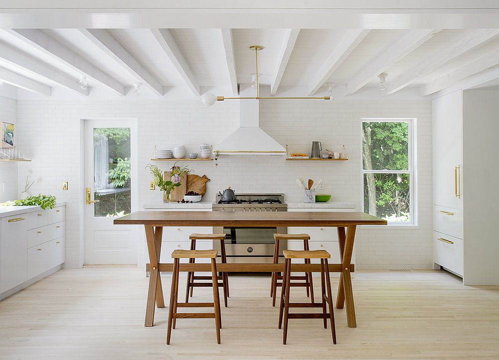 Kitchen of the Hamptons home in white with wooden table and chairs