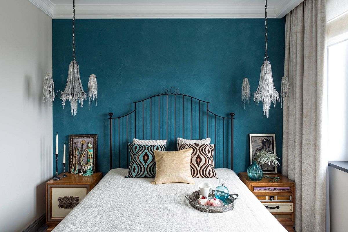 Modern and eclectic touches combined in the white bedroom with deep blue accent wall