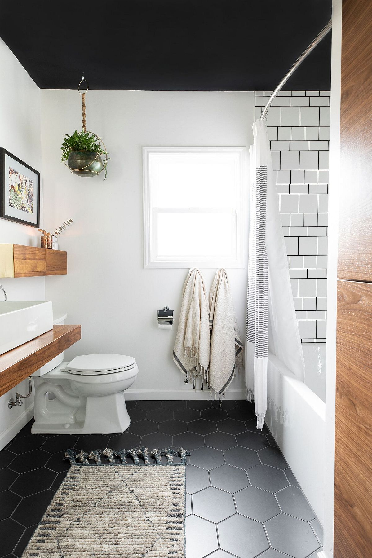 Modern-bathroom-in-black-and-white-with-wooden-accents-and-vanity-has-a-floor-with-hexagonal-tiles-96314