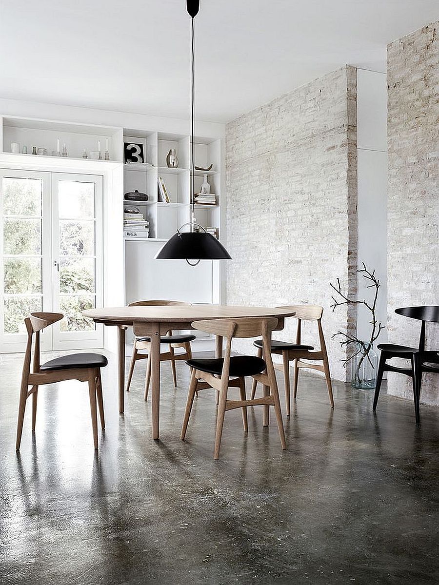 Painting the exposed brick wall white in the industrial style dining rooms with black chairs