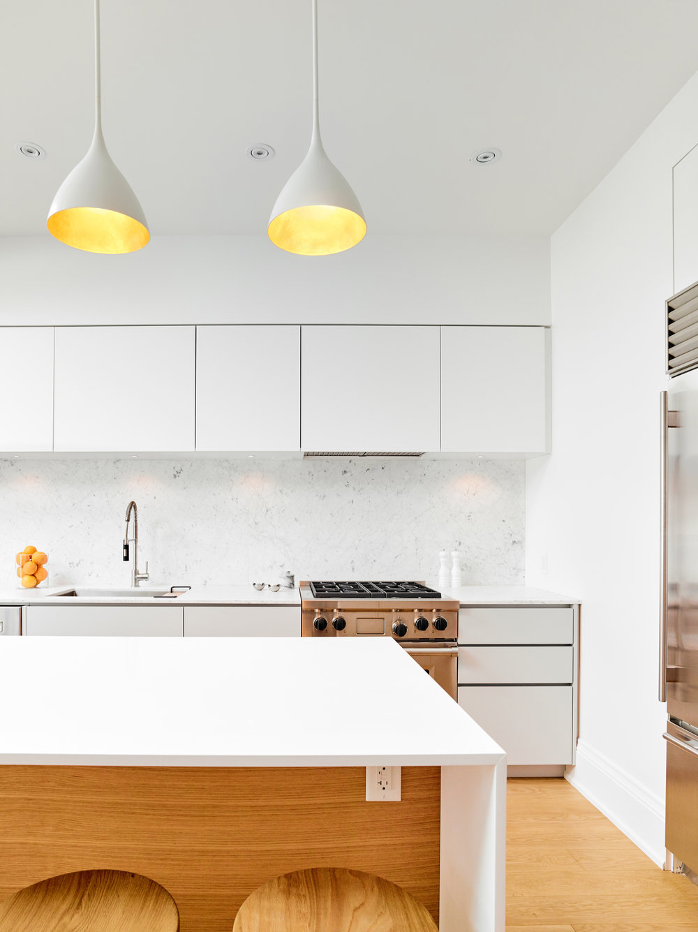 Pendants accentuate the modern minimal style of the kitchen while adding metallic sparkle