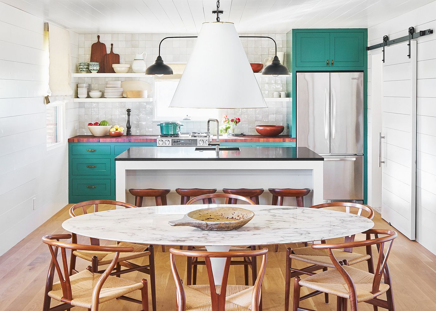 Small and elegant ranch style kitchen in Texas home with tiled-backsplash and teal cabinets