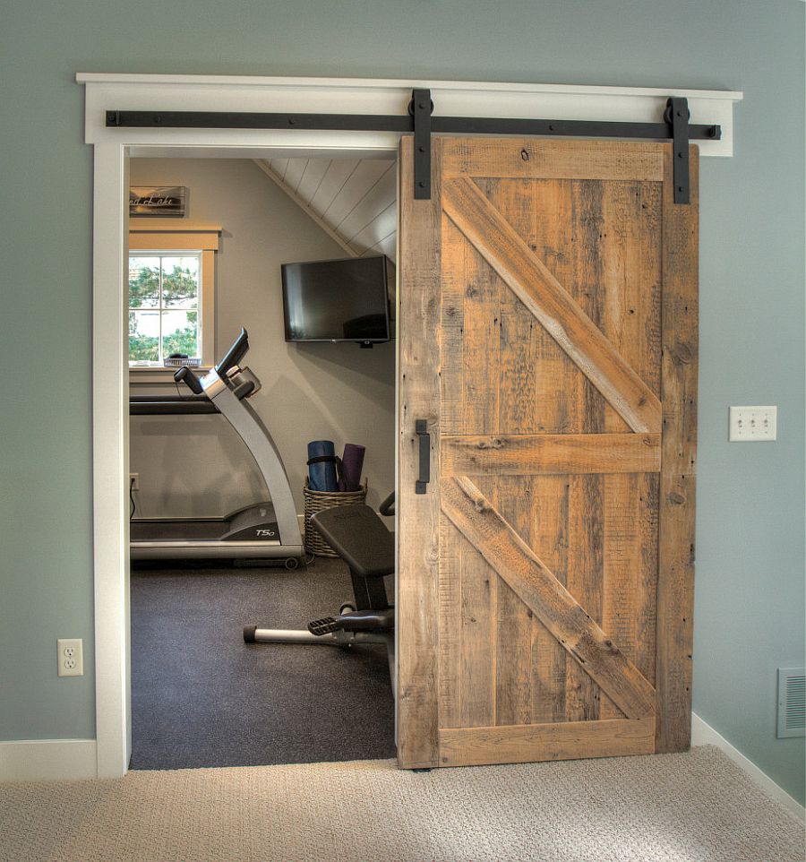 Small transitional style home gym sits behind the sliding arn door in here