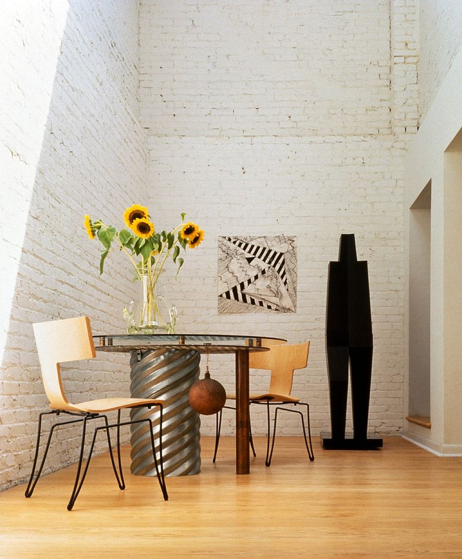 Spacious dining area in revamped home with white brick walls and plenty of natural light