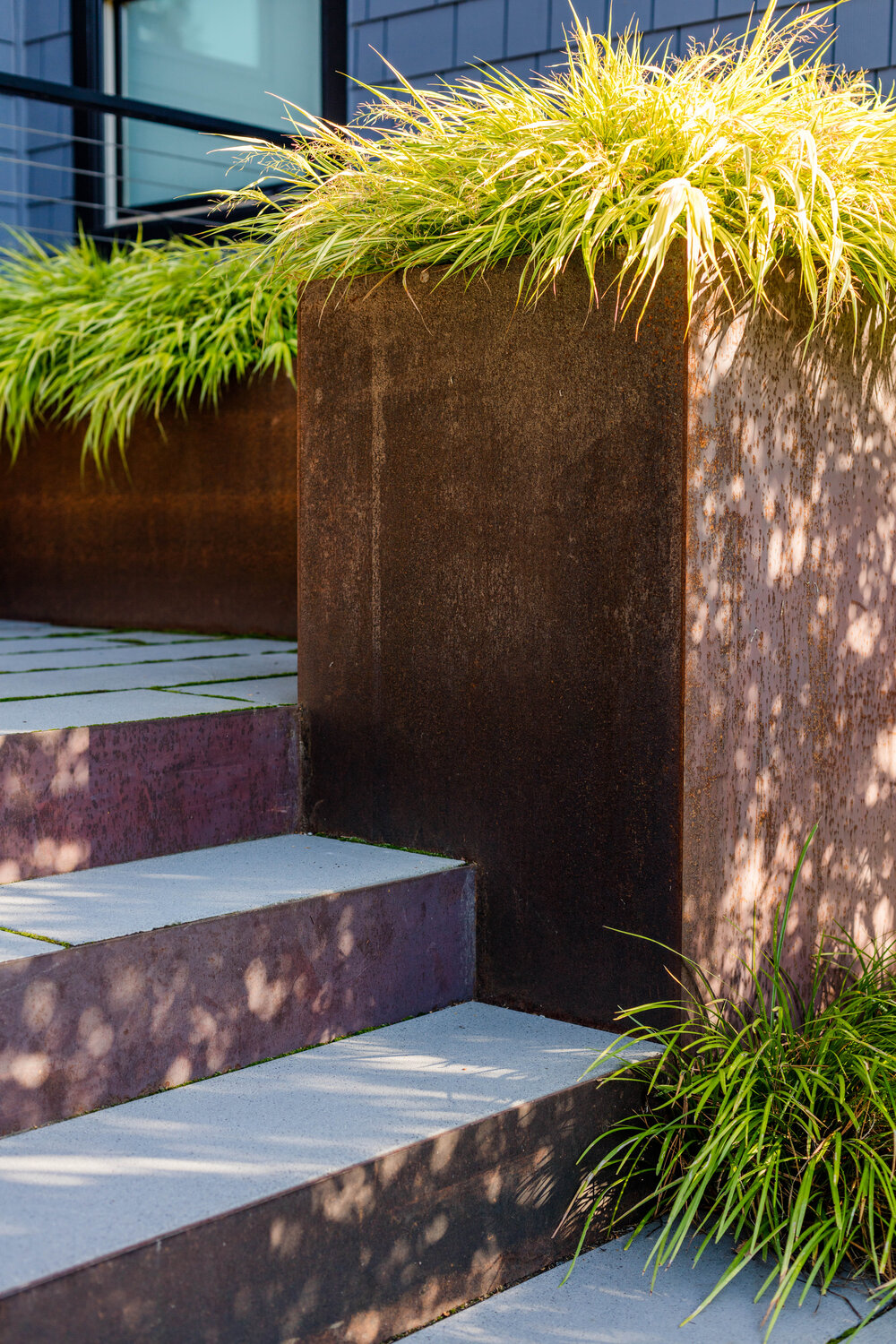 Steel and concrete steps welcome you inoto the lovely home and series of patios around it