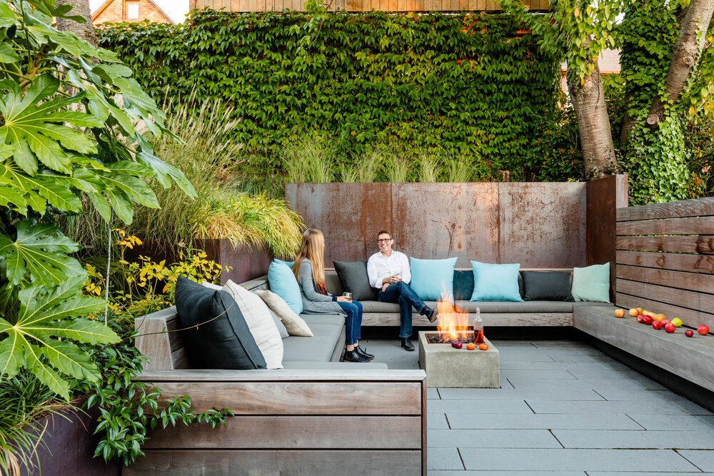 Sunken patio becomes private outdoor conversation pit with a gorgeous fireplace and comfy seating