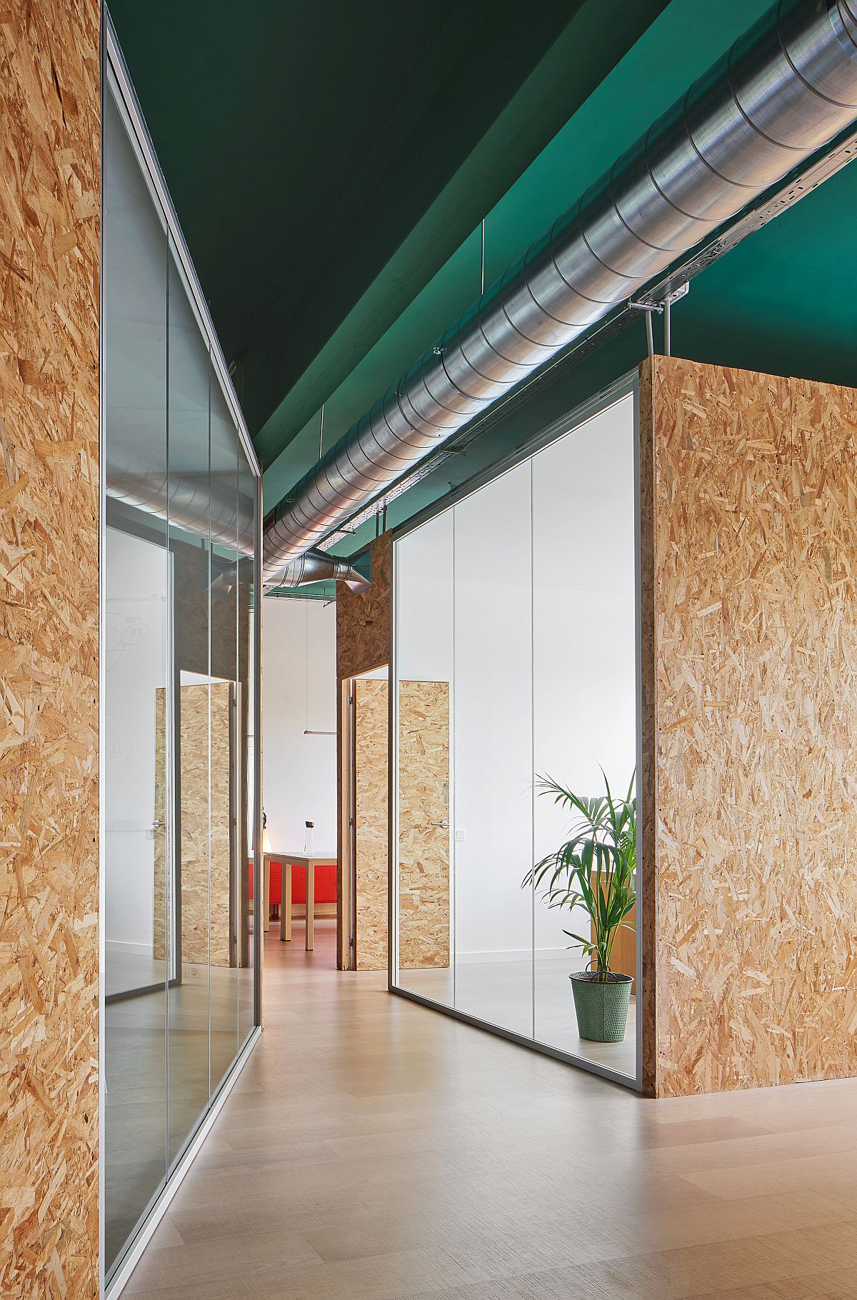 Two distinct boxes inside the office building serve as meeting room and management space