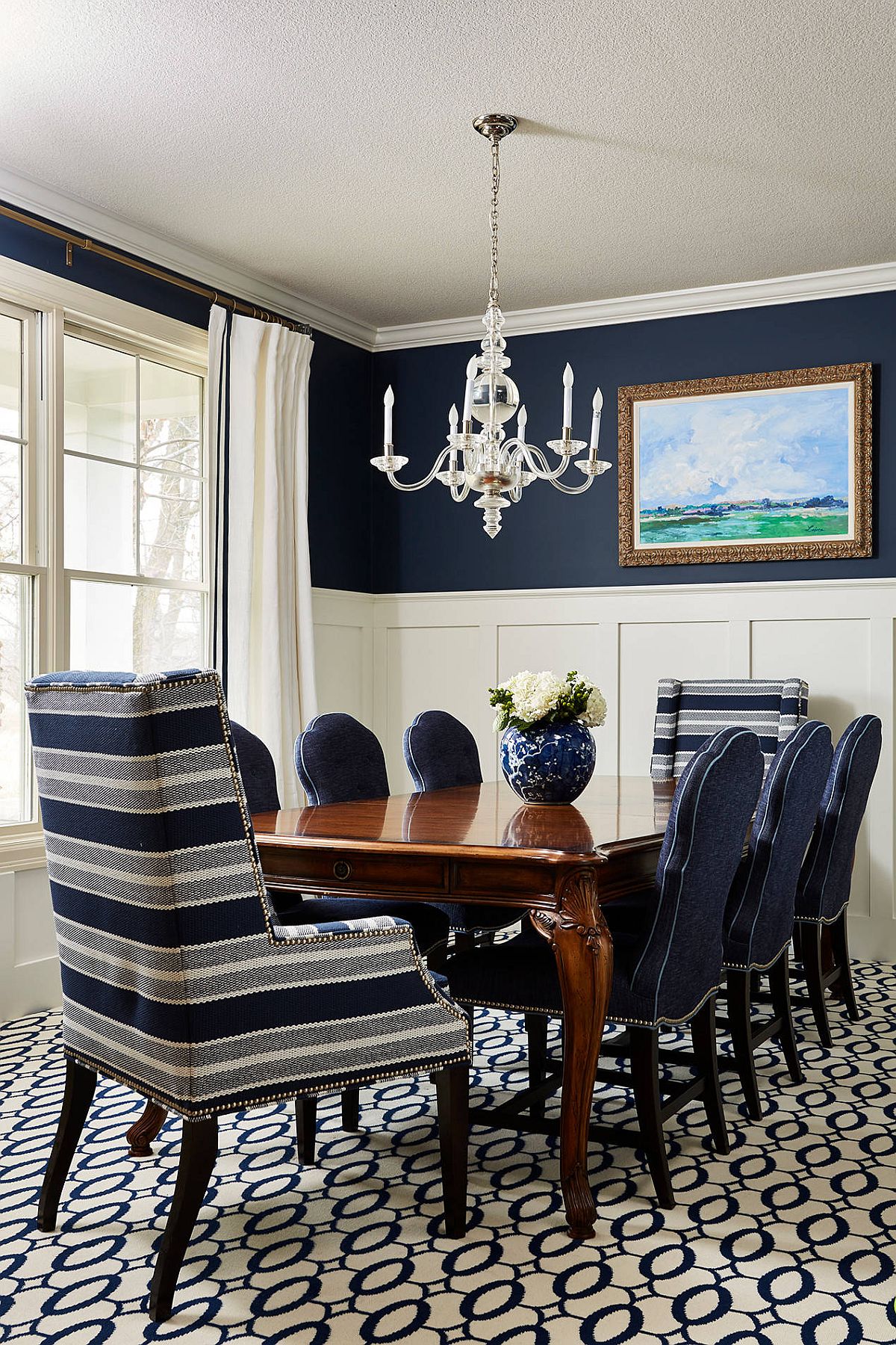 Two striped accent chairs bring pattern to the blue and white dining room without disturbing its color scheme