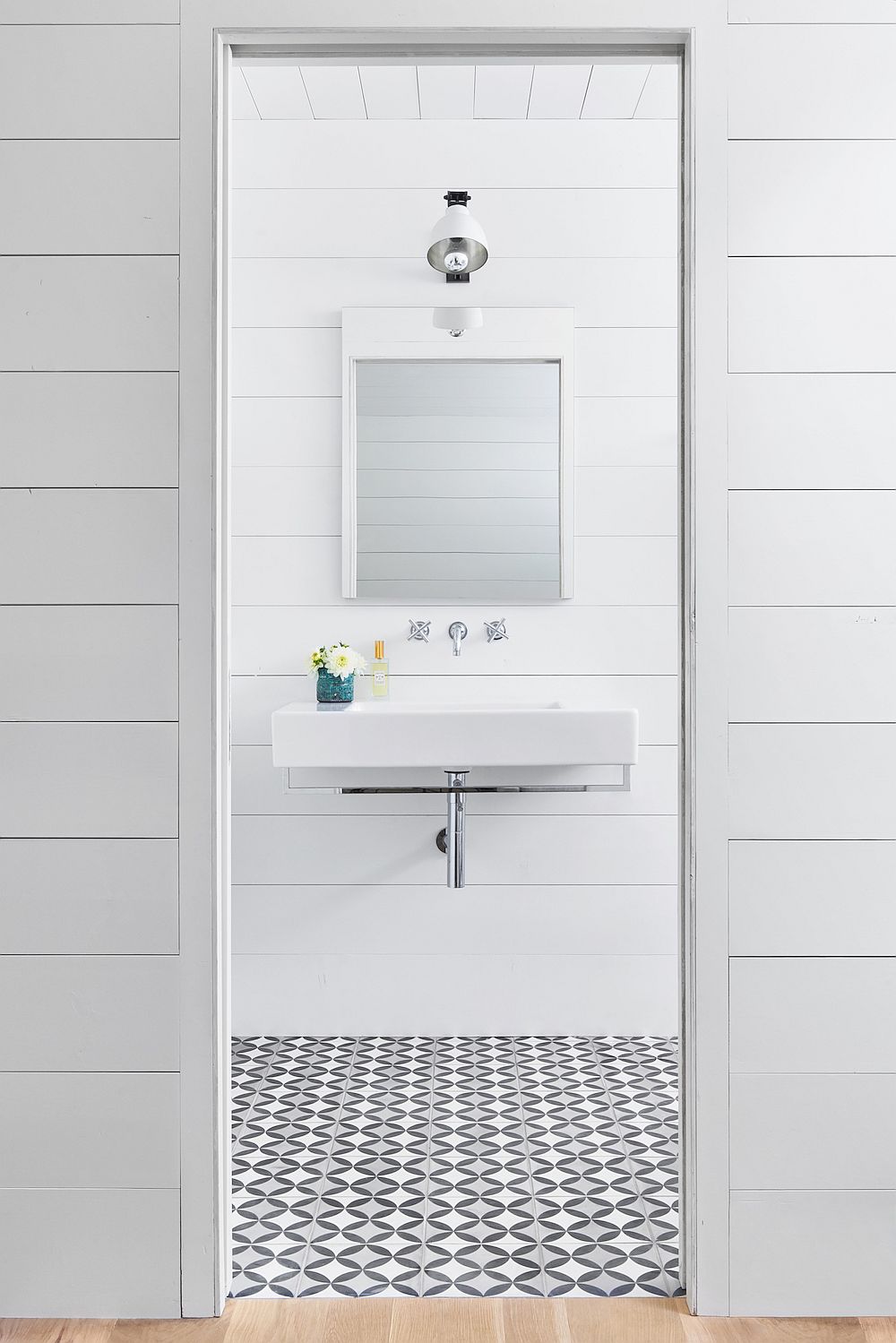 White bathroom with patterned tile floor and a space-savvy design