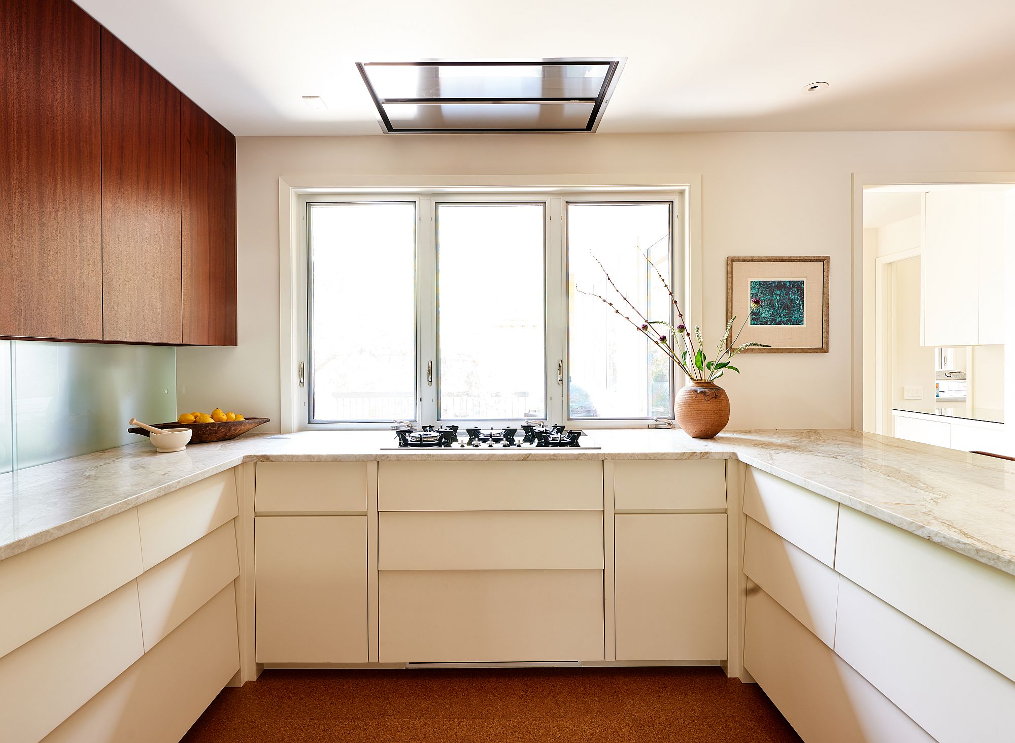 Windows bring natural light into the spacious kitchen with cork floors