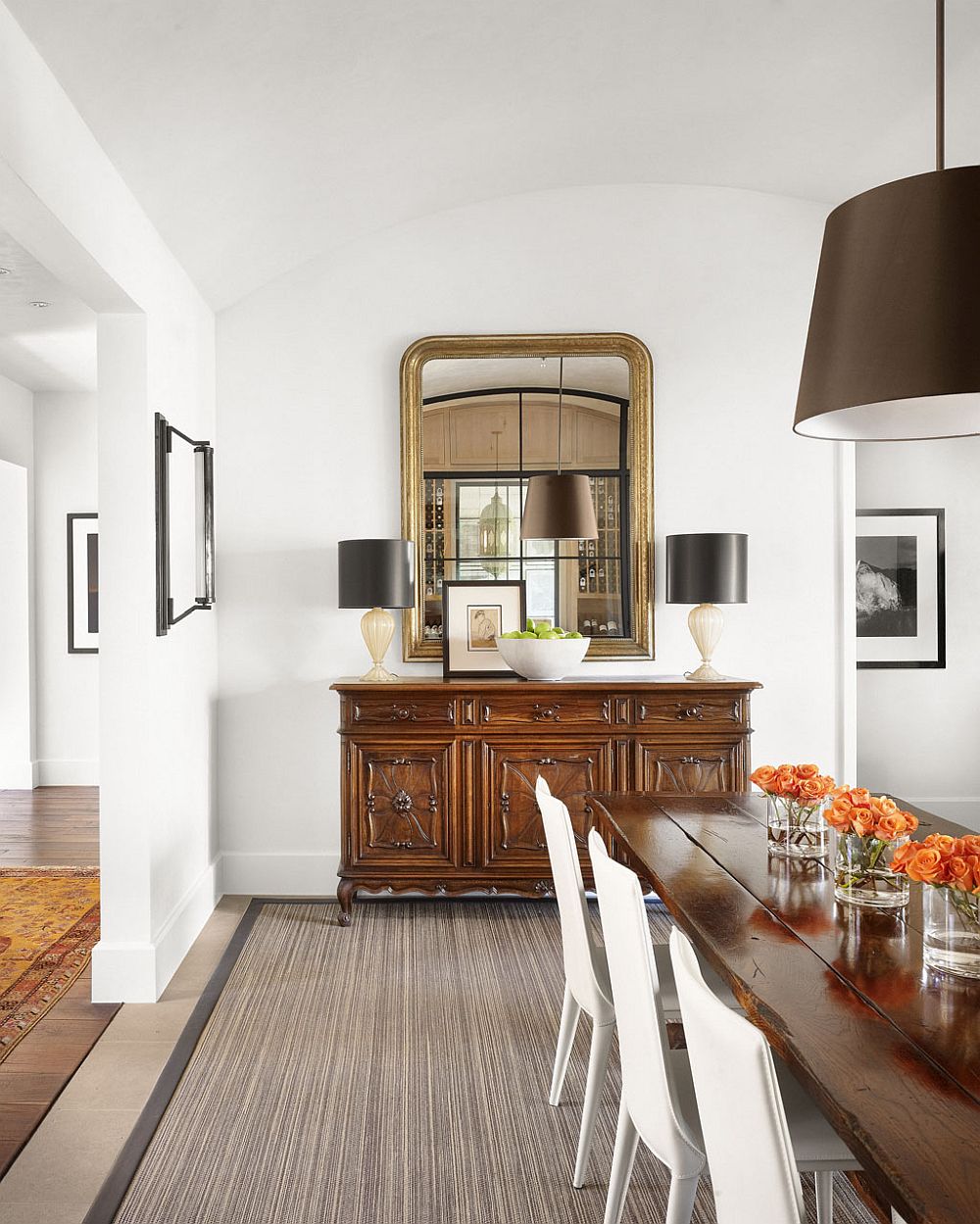 Adding a bit of opulence to the dining room with gold mirror frame and dark table lamps