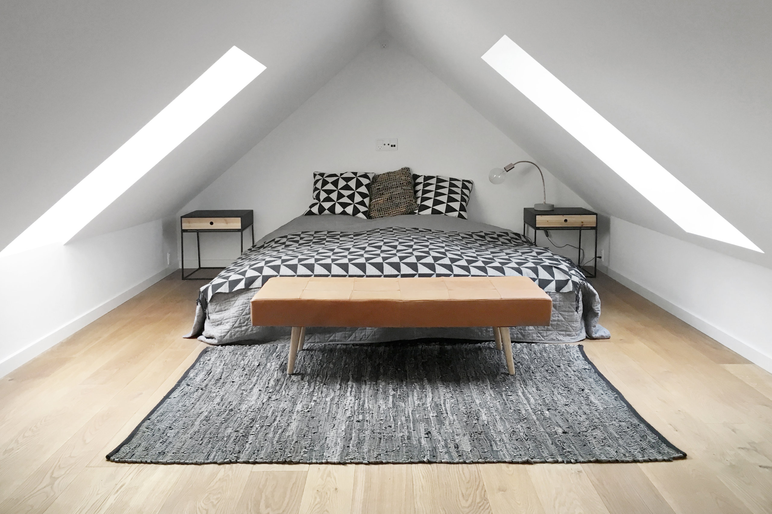 Attic bedroom with ample natural light and bedding that adds pattern