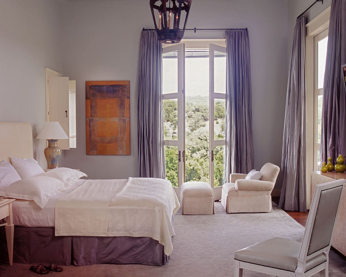 Bedroom in white with drapes in light blue and ample natural light